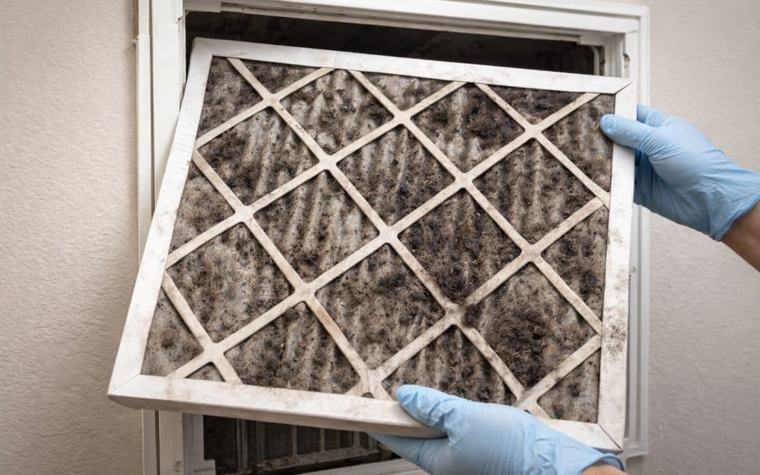 Dirty air filter covered in dust and mold being removed from a home HVAC vent